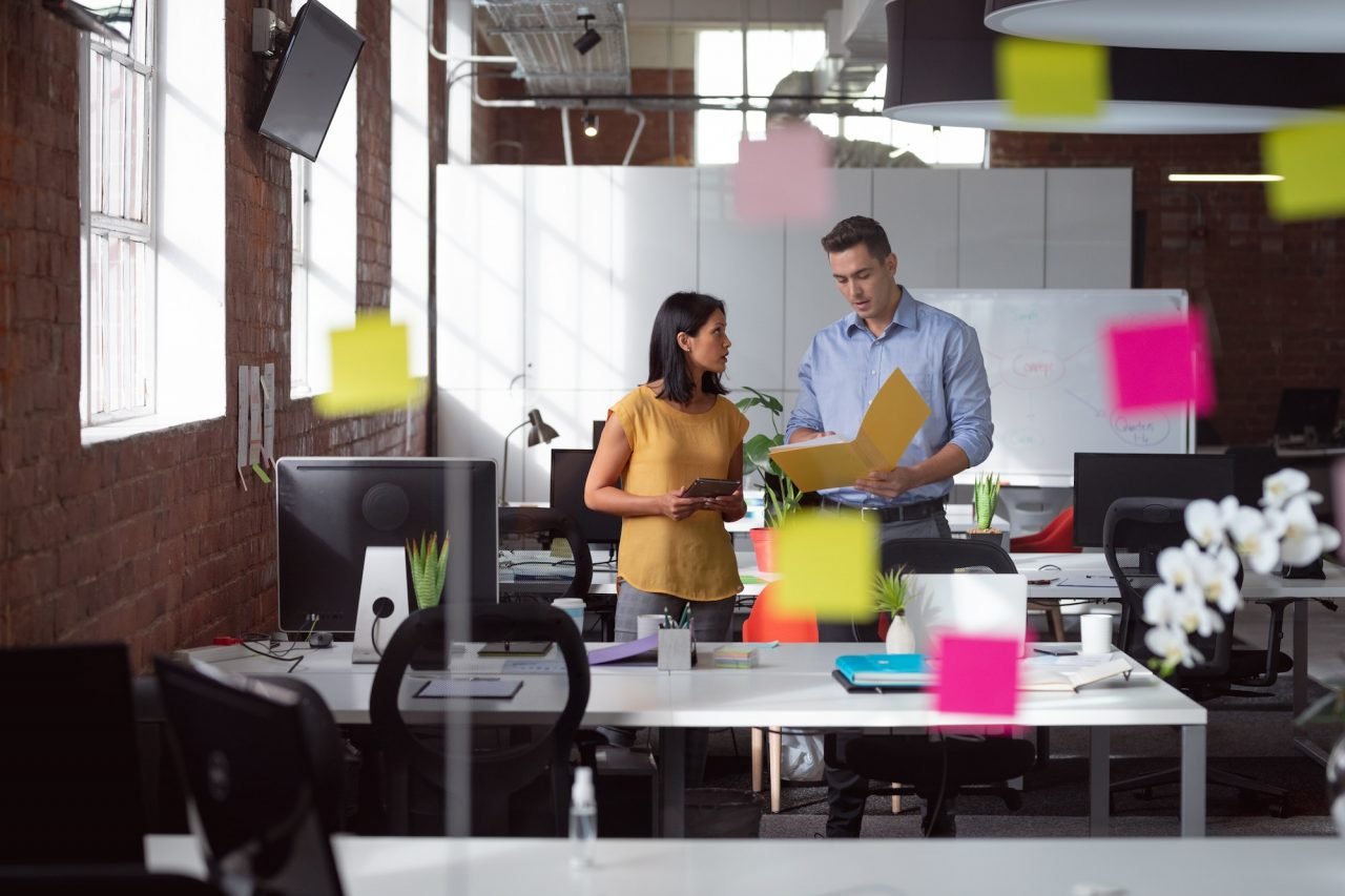 caucasian-male-and-female-colleague-discuss-tablet-and-file-view-through-glass-wall-and-memo-notes.jpg