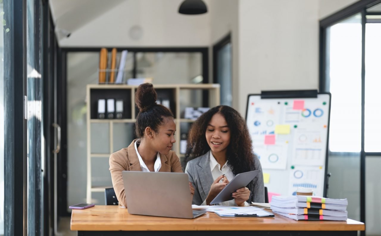 two-young-business-people-working-together-in-office-financial-analysis-accounting-concept-.jpg